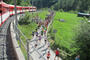 The spectators in the travelling bleachers in the Matterhorn Gotthard Bahn cheer the runners on.